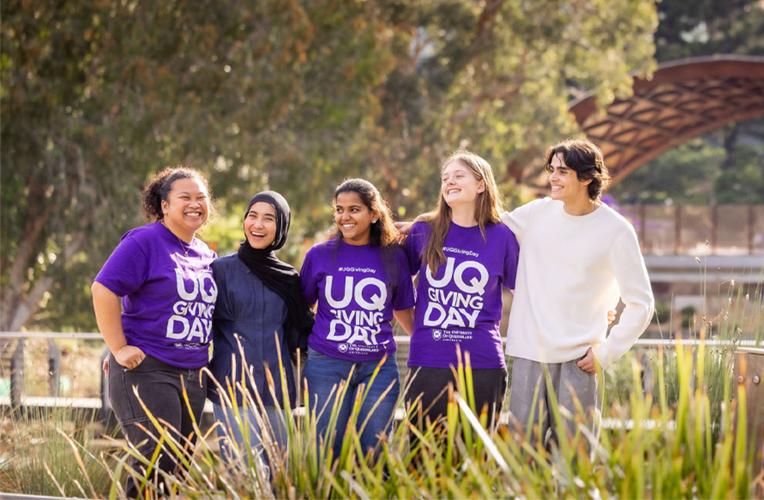 Student ambassadors stand at the Lakes with purple Giving Day shirts.