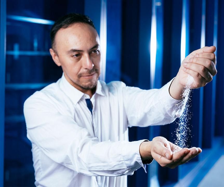 Dr Axayacatl Gonzalez pouring white sugar crystals from one hand to the other.