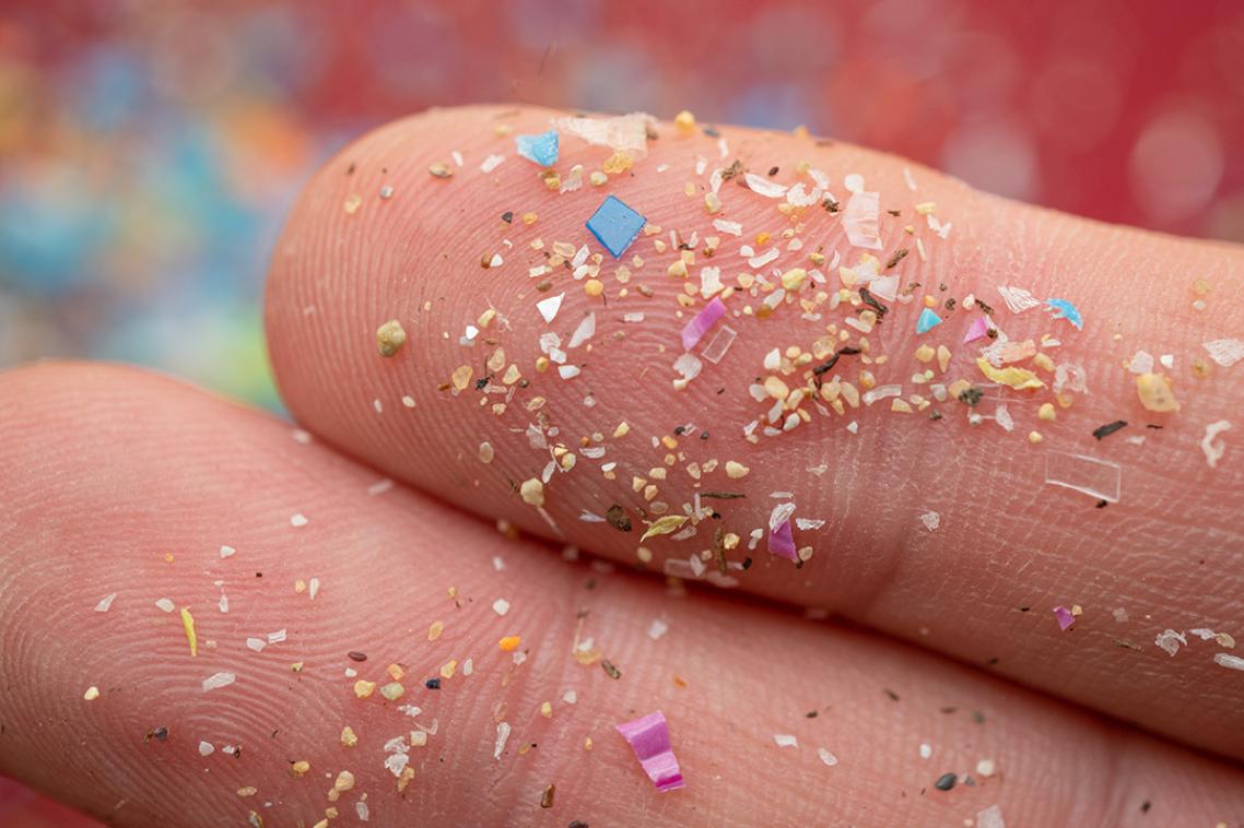 Close-up of microsplastic examples on a person's finger.